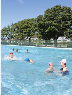 今年初の「真夏日」。屋外プールで泳ぎを楽しむ子どもたち（能代市万町で）