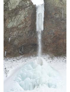 青色が美しい氷のドームと、滝口に氷塊を形成している銚子の滝