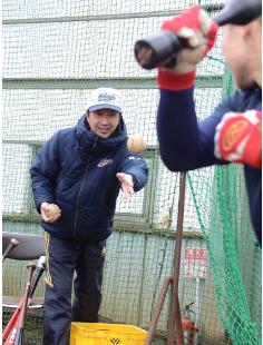 打撃練習で選手にトスを上げる長岡さん