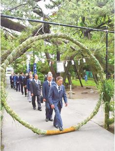 静かに茅の輪をくぐる参列者たち（能代市柳町の八幡神社で）