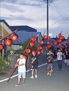 赤い提灯をつるした竿を担いだ行列が地区内を練り歩いた「ねぶ流し」（藤里町藤琴で）