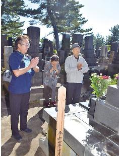 彼岸の中日の23日、墓前に手を合わせる住民の姿が広がった（能代市萩の台で）