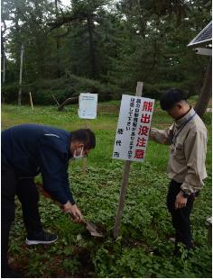 「立ち入り禁止」の掲示から「熊出没注意」の看板に切り替える能代市職員（風の松原で）