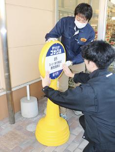 市職員がまちなかコサクルの停留所を設置（いとく能代南店前で）