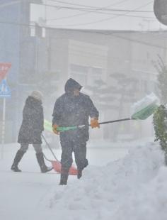 朝から雪かきに追われる住民（能代市若松町で）