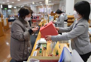 新春恒例企画の「おみくじ」を引き、今年の〝読書運〟を占う（能代図書館で）