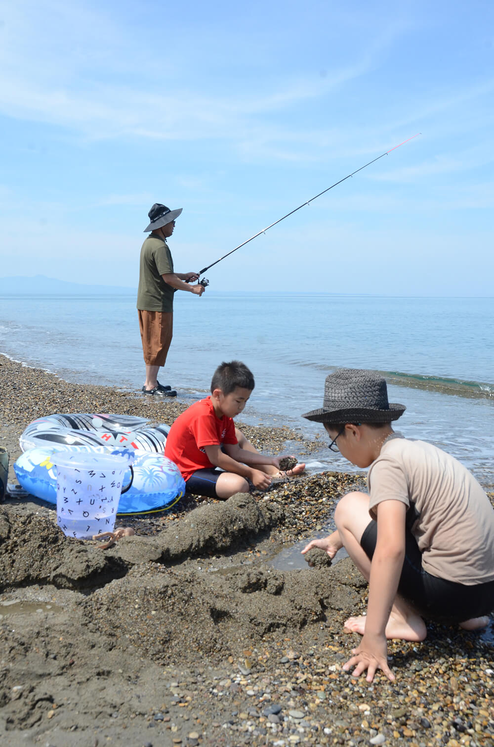 波打ち際で涼を取る家族連れ（三種町の釜谷浜で）