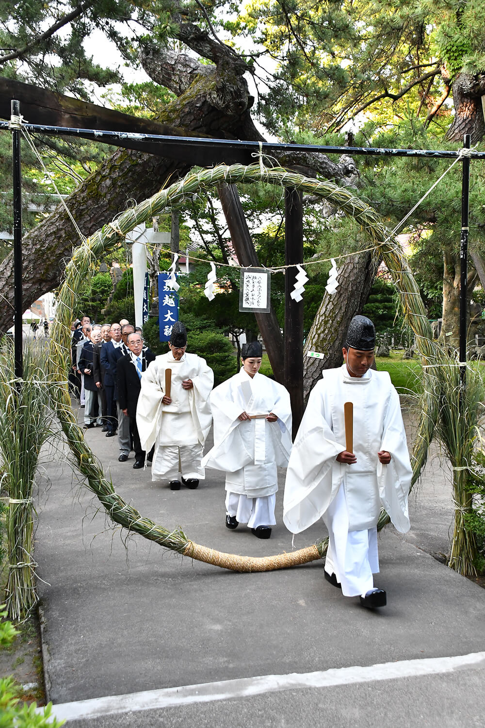 夏越の大祓で茅の輪をくぐる神職ら（能代市柳町の八幡神社で）