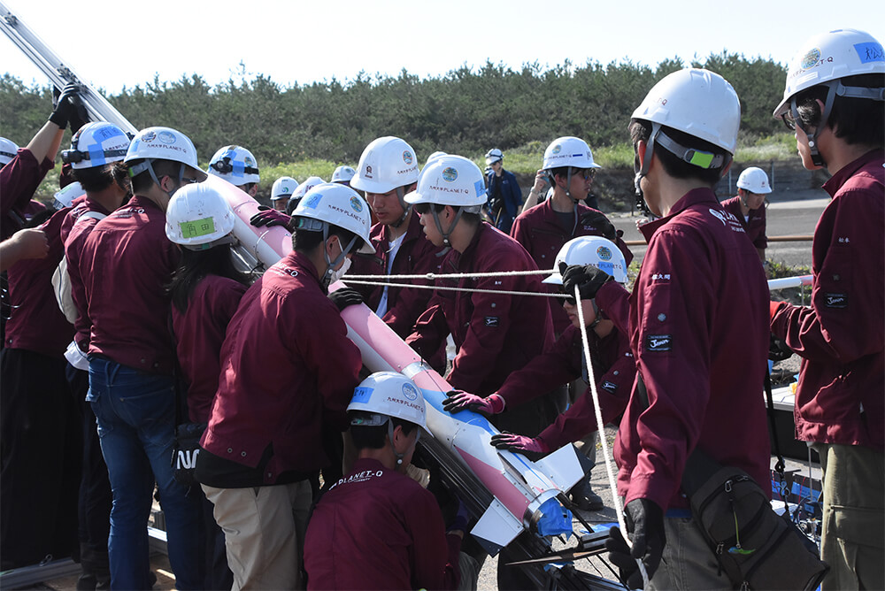 ハイブリッドロケットの発射準備をする九州大の学生たち（能代市の落合浜で）