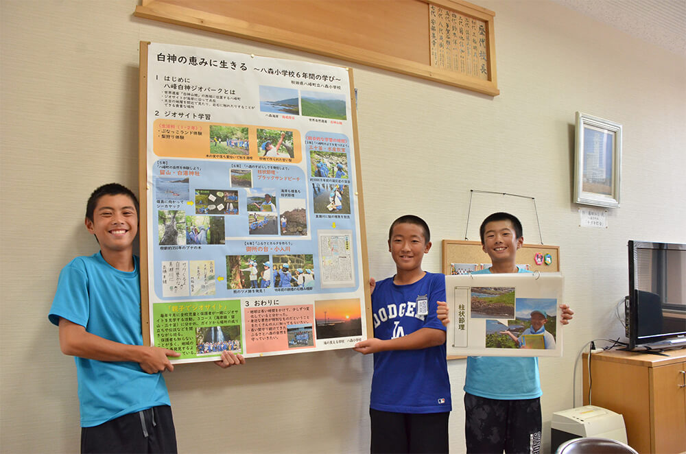 日本ジオパーク全国大会のポスター部門に参加する八峰町八森小６年の（左から）小林君、日沼君、吉村君