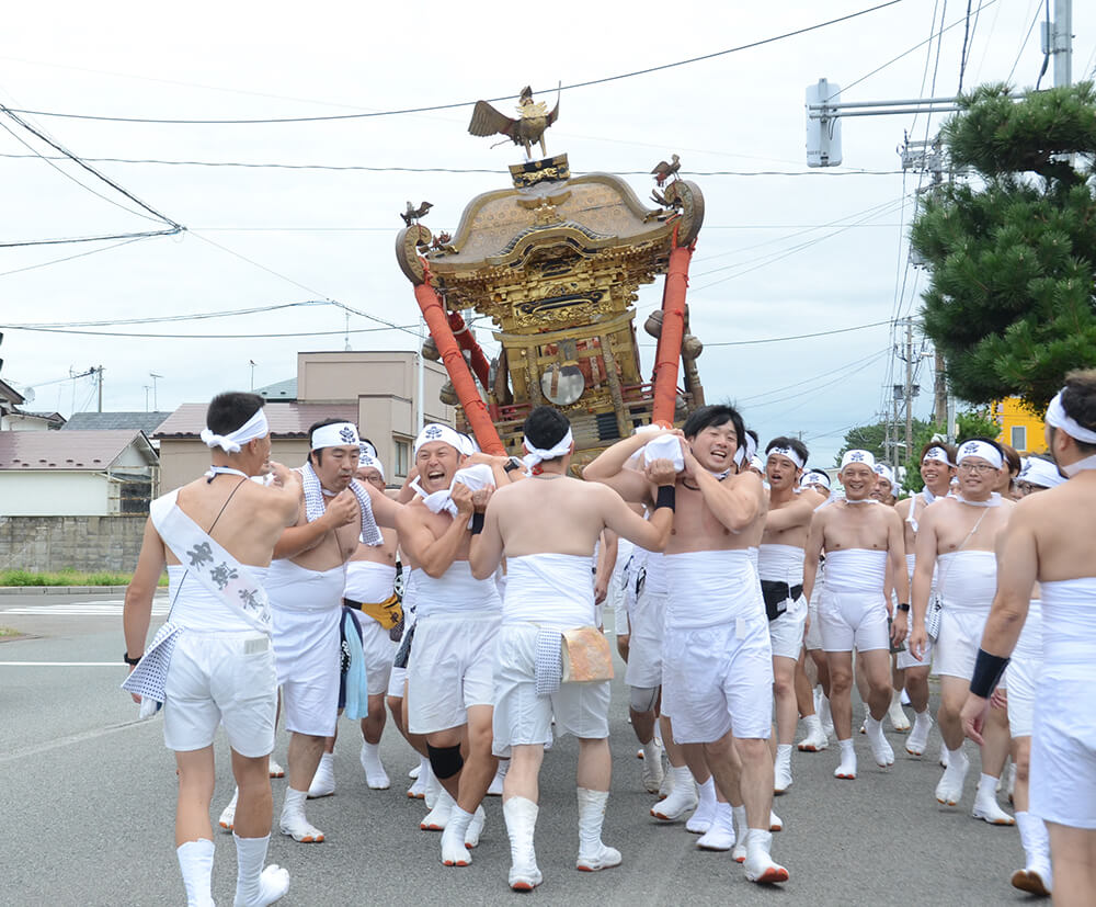 男衆が威勢のいい掛け声を響かせ、みこしが練り歩いた（能代市内で）