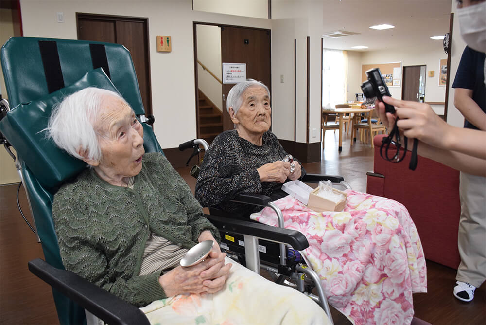 内閣総理大臣から贈られた銀杯を手にする梅田さん（左）と丹波さん