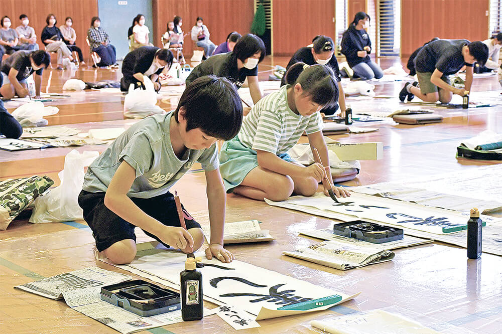 子どもたちが真剣な面持ちで臨んだ毛筆席書大会（能代市落合のＢ＆Ｇ海洋センター体育館で）