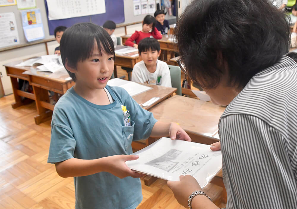 担任教諭から前期の通知表を受け取る１年生（４日、能代市渟西小で）