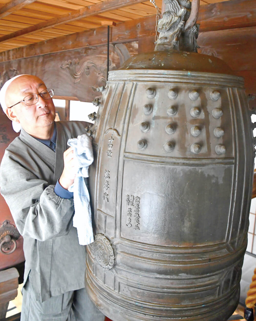 大みそかを前に、梵鐘を丁寧に磨き上げる住職（三種町鵜川の鳳来院で）