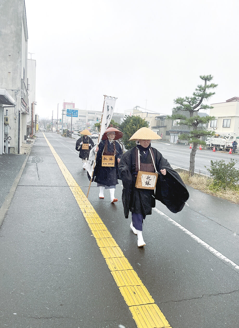 能代市中心部で持鈴の音を響かせながら、托鉢を行った僧侶たち