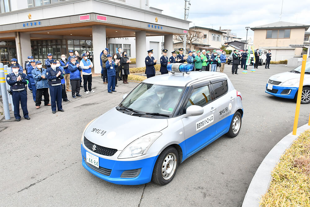 出席者に見送られ、青色防犯パトロール車が能代署を出発