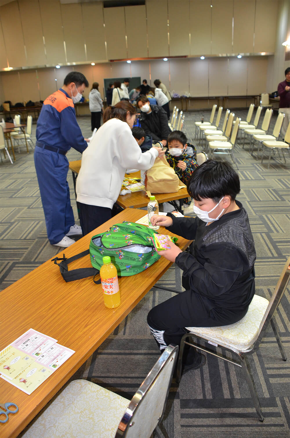 有事に備えて菓子などをリュックに詰め込む小学生（八峰町峰浜田中の峰栄館で）