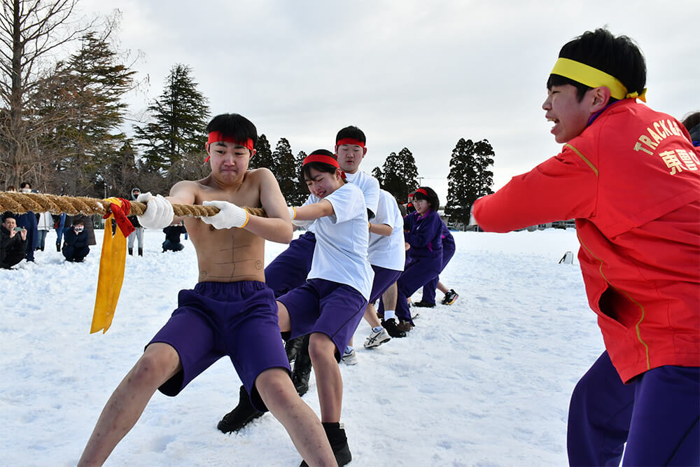 クラスメートと協力し熱戦を展開した「雪中綱引き」（能代市東雲中で）